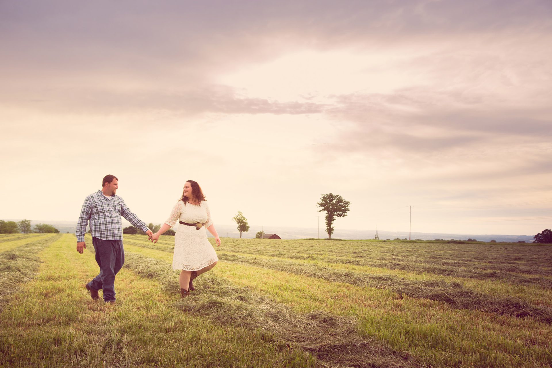 Couple walking in hay field